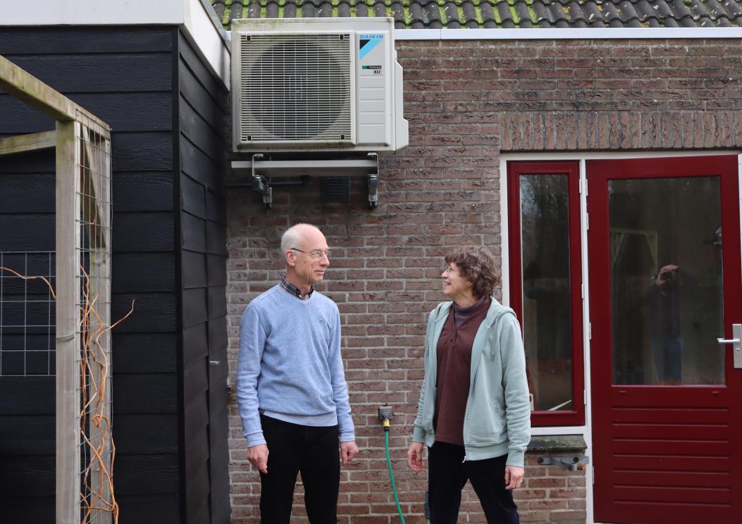 Twee mensen buiten bij warmtepomp aan het huis